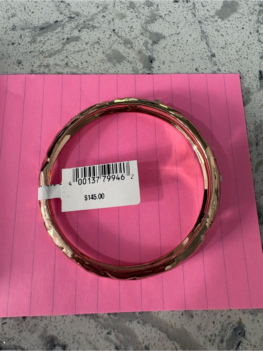 Alexis Bittar bangle features a molten gold texture with embedded clear crystals